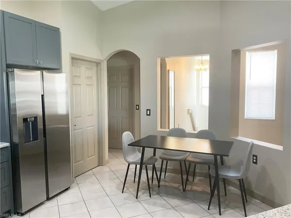 a kitchen with stainless steel appliances a refrigerator a table and chairs in it