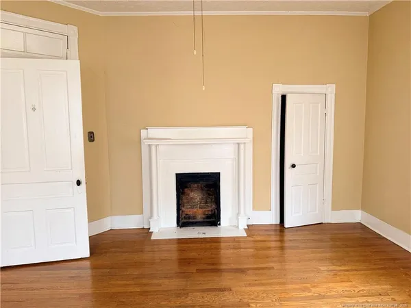 a view of a livingroom with wooden floor and a fireplace