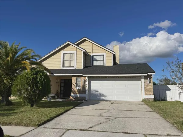 a front view of a house with a garden and trees