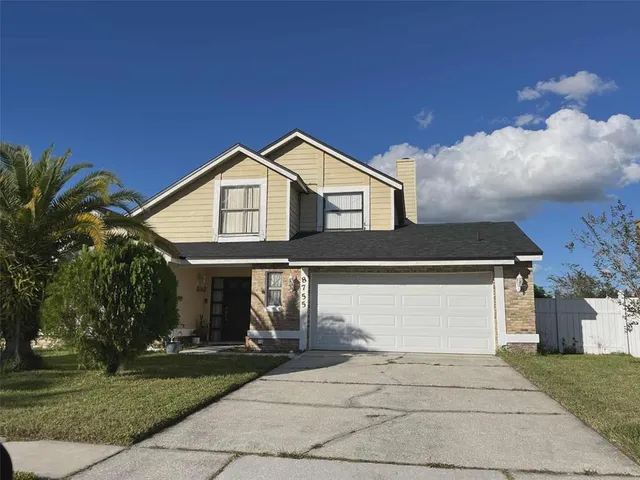 a front view of a house with a garden and trees