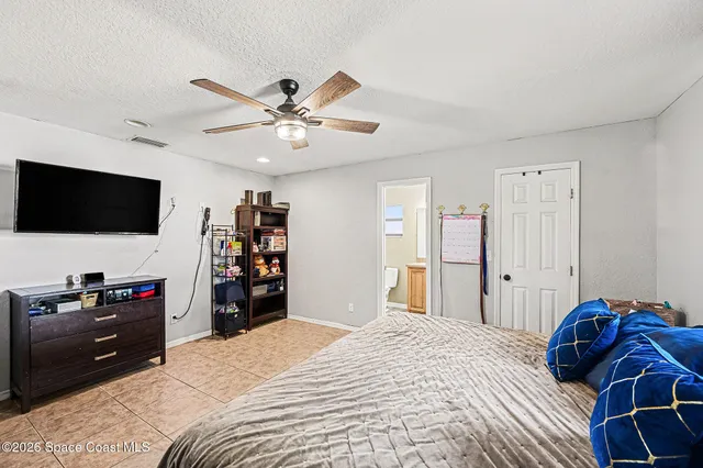 a bedroom with a bed and a flat tv screen on wall