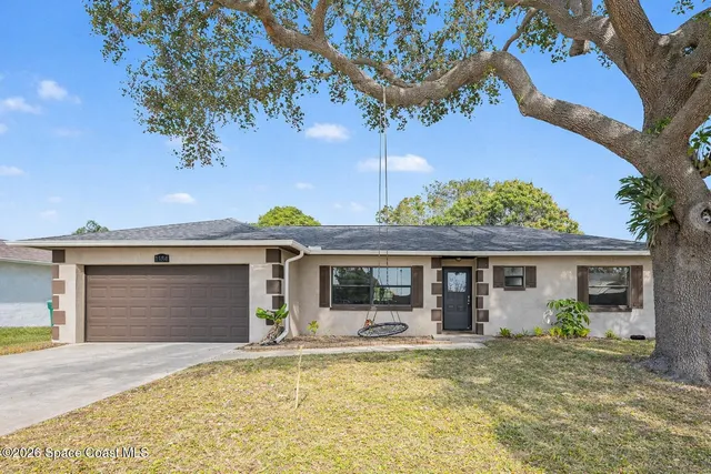 a view of a house with a swimming pool and a yard