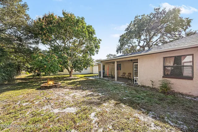 a view of a house with backyard and trees