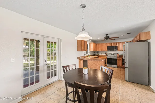 a view of a dining room and livingroom with furniture wooden floor a chandelier