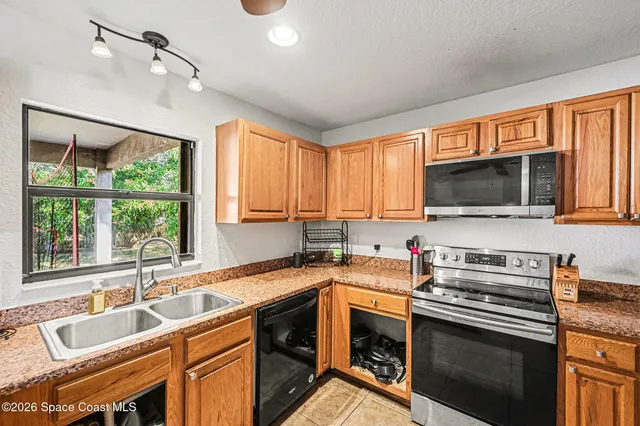 a kitchen with stainless steel appliances a stove sink microwave and cabinets