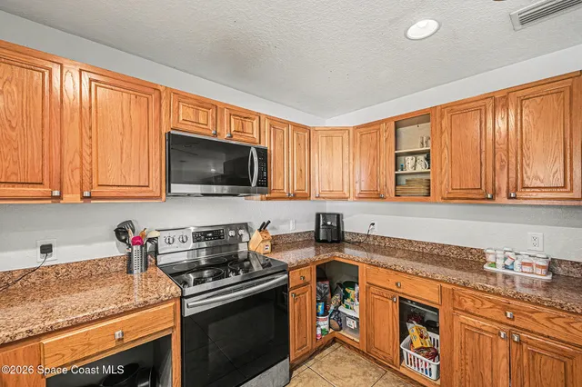 a kitchen with stainless steel appliances granite countertop a stove a sink and a microwave