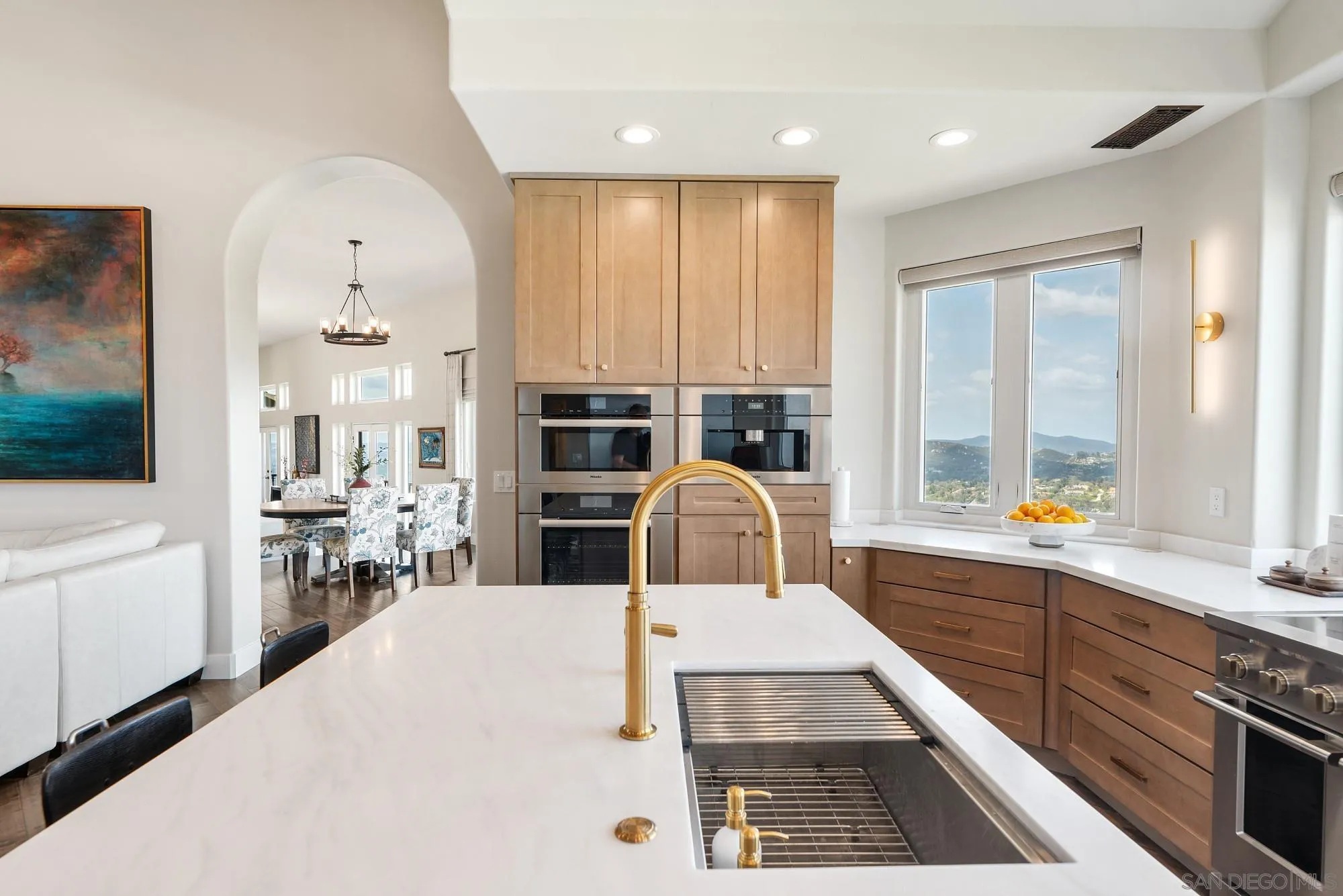 15484 Markar Road Poway, CA 92064 - Photo 15 of 75 a kitchen with stainless steel appliances a stove a sink and white cabinets with wooden floor