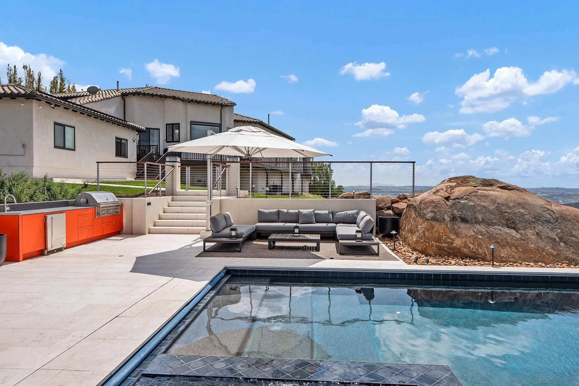 15484 Markar Road Poway, CA 92064 - Photo 57 of 75 a roof deck with table and chairs under an umbrella with large trees