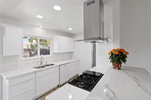 a kitchen with stainless steel appliances a sink stove and cabinets