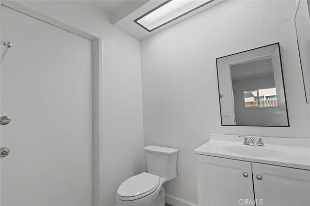 a bathroom with a toilet a sink and mirror