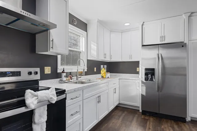 a kitchen with a sink dishwasher a refrigerator and cabinets