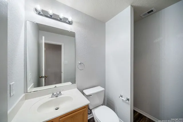 a bathroom with a toilet a sink and mirror