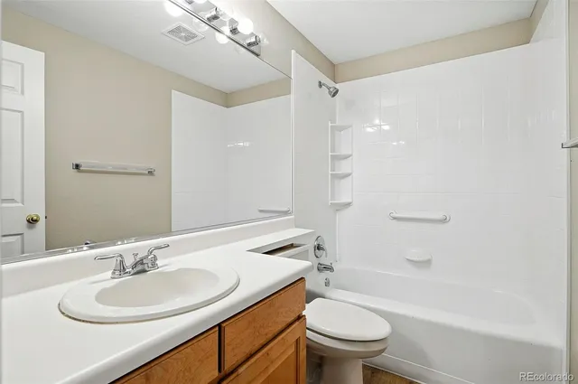 a bathroom with a sink a toilet and a large mirror