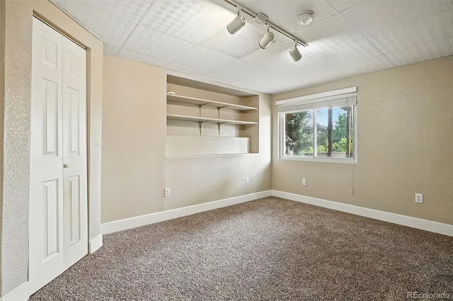 an empty room with windows and closet area