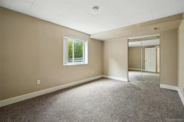 an empty room with windows and closet
