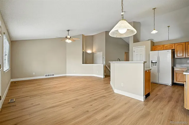 a view of a kitchen with a refrigerator a stove top oven and cabinets