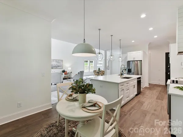 a kitchen with stainless steel appliances kitchen island a table and chairs in it