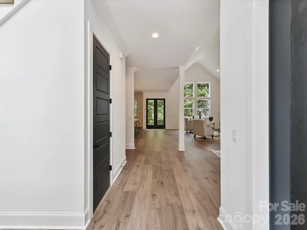 a view of a hallway with wooden floor and furniture