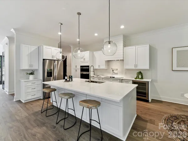 a view of kitchen with stainless steel appliances kitchen island a table chairs stove and refrigerator