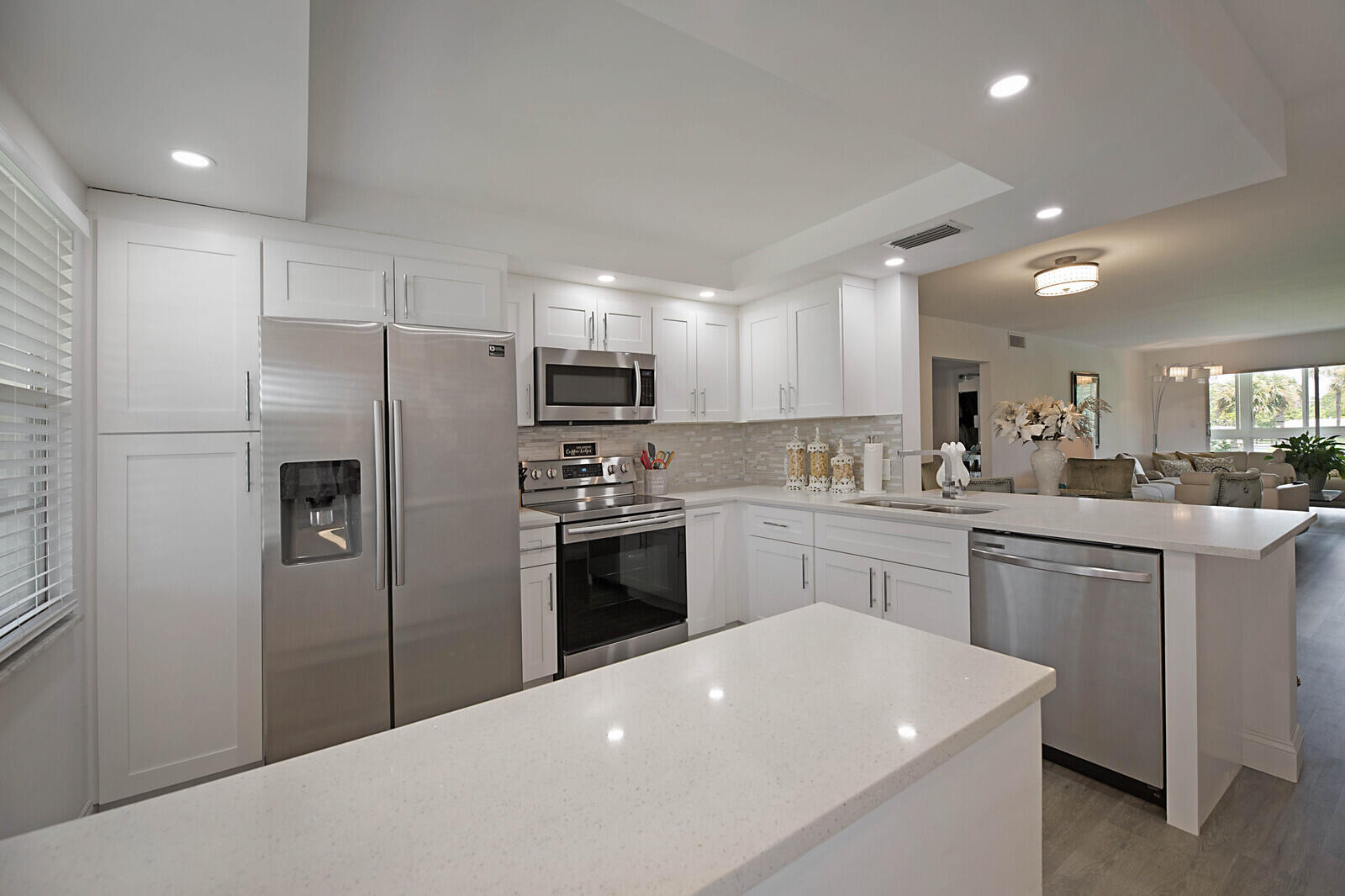 a kitchen with a refrigerator a sink stainless steel appliances and cabinets