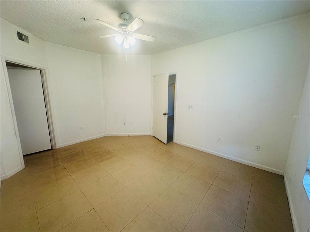 5560 Metrowest Boulevard, Unit 101 Orlando, FL 32811 - Photo 12 of 30 an empty room with a ceiling fan and a window