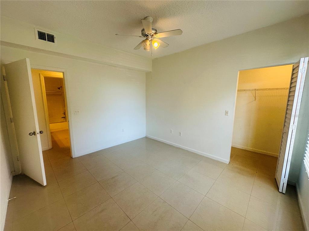5560 Metrowest Boulevard, Unit 101 Orlando, FL 32811 - Photo 14 of 30 an empty room with a ceiling fan and a bathroom
