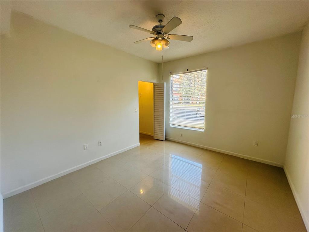 5560 Metrowest Boulevard, Unit 101 Orlando, FL 32811 - Photo 16 of 30 an empty room with windows and ceiling fan