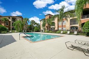5560 Metrowest Boulevard, Unit 101 Orlando, FL 32811 - Photo 26 of 30 a view of a swimming pool with a yard and plants