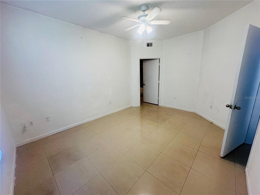 5560 Metrowest Boulevard, Unit 101 Orlando, FL 32811 - Photo 9 of 30 an empty room with a ceiling fan and a window