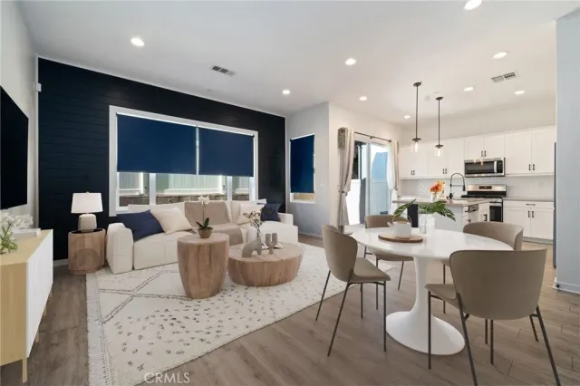 a living room with furniture and a view of kitchen