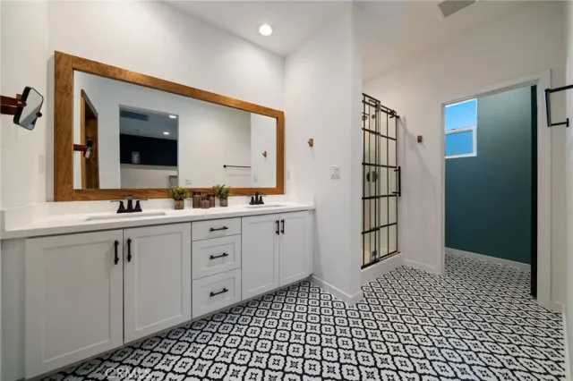a spacious bathroom with a double vanity sink and mirror