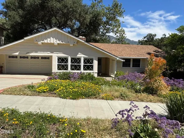 a front view of house with flowers