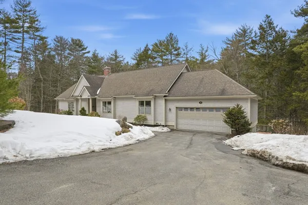 a white house with a large tree in front of it