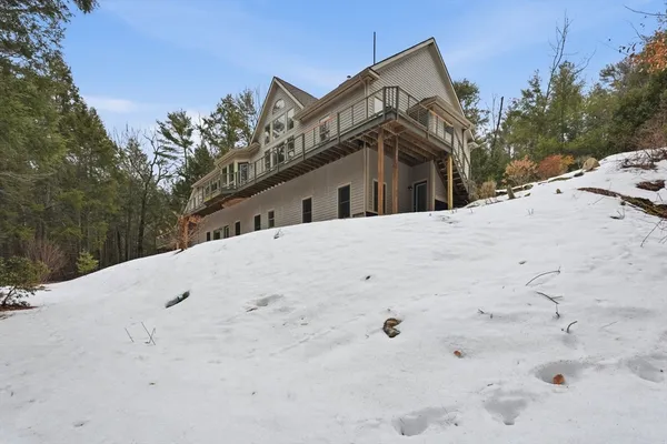 a view of a white house with a snow on the road
