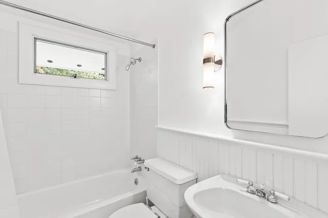 a bathroom with a bathtub shower sink and mirror