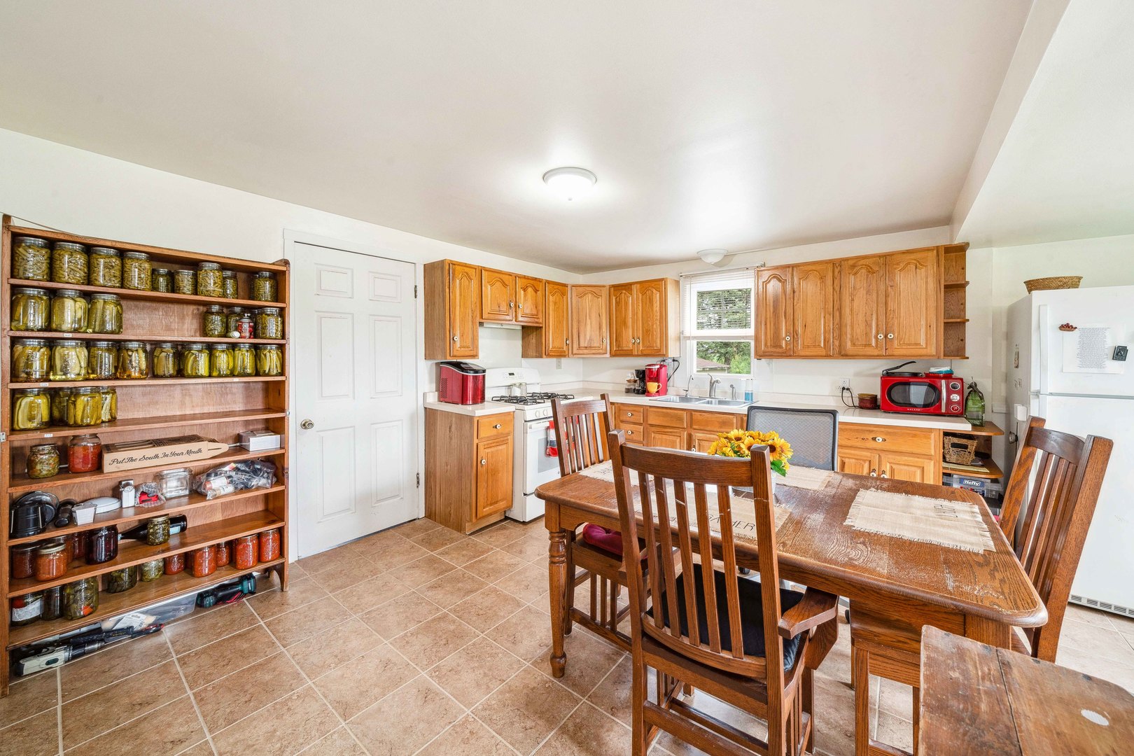 15589 Chicago Road Sandwich, IL 60548 - Photo 5 of 30 a open kitchen with stainless steel appliances a stove a table and chairs