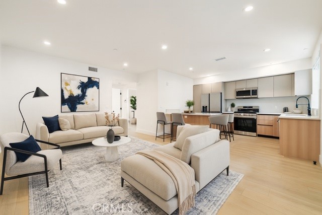 7510 Sepulveda Boulevard, Unit 204 Van Nuys, CA 91405 - Photo 1 of 24 a living room with furniture and kitchen view