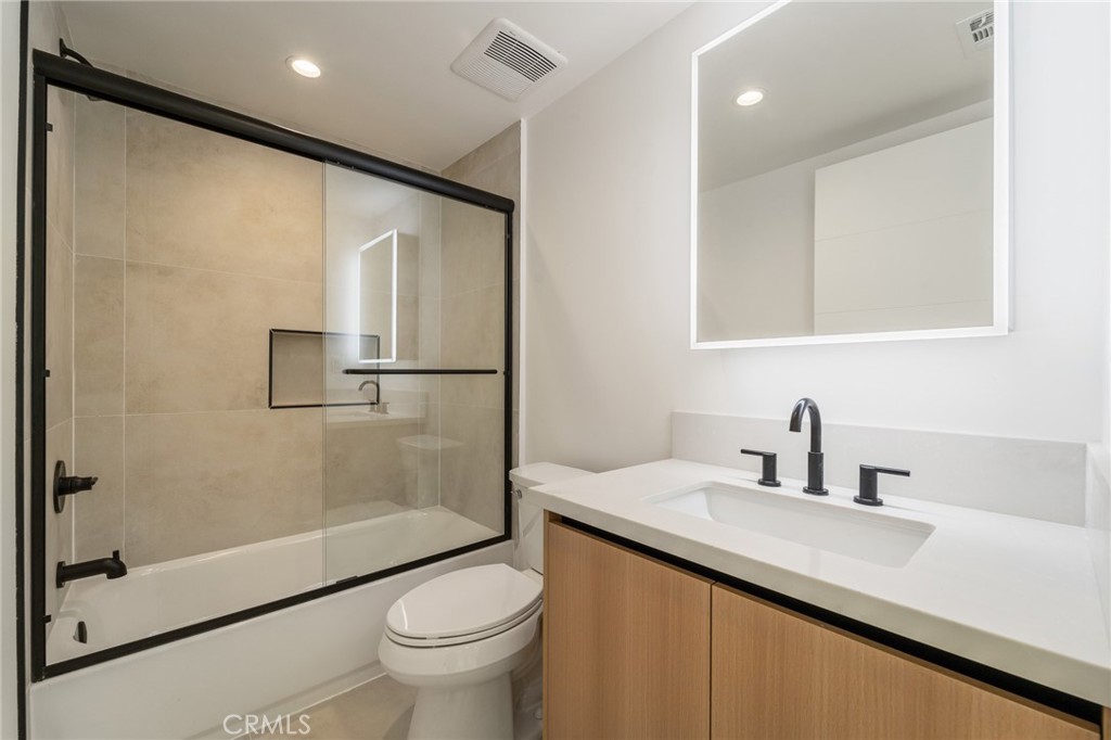 7510 Sepulveda Boulevard, Unit 204 Van Nuys, CA 91405 - Photo 16 of 24 a bathroom with a shower sink vanity mirror and toilet