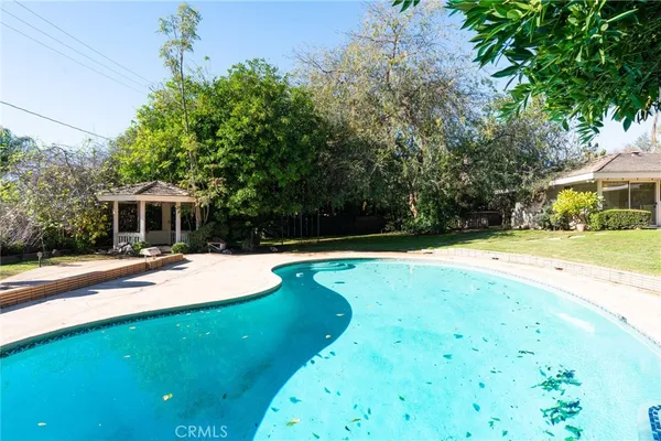 a swimming pool with outdoor seating and yard