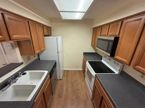 a kitchen that has a sink and wooden floor