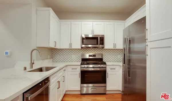 a kitchen with appliances a sink and cabinets
