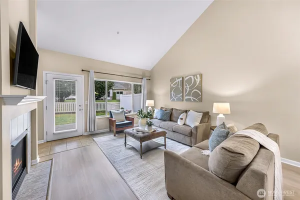 a living room with furniture a fireplace and a flat screen tv