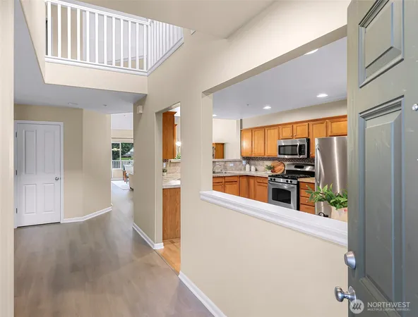 a kitchen view with stainless steel appliances wooden floor and a refrigerator