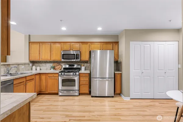 a kitchen with granite countertop a refrigerator stove top oven and sink