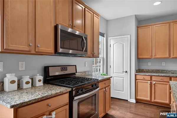 a kitchen with granite countertop wooden cabinets and a stove top oven