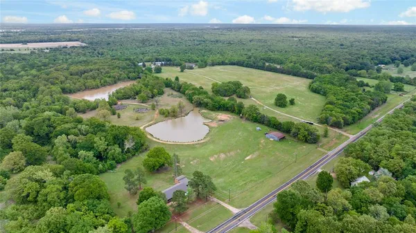 an aerial view of residential houses with outdoor space and trees