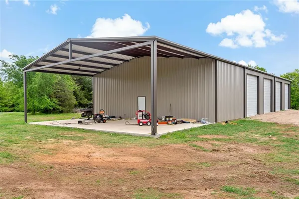 a view of a backyard with hardwood area and garage