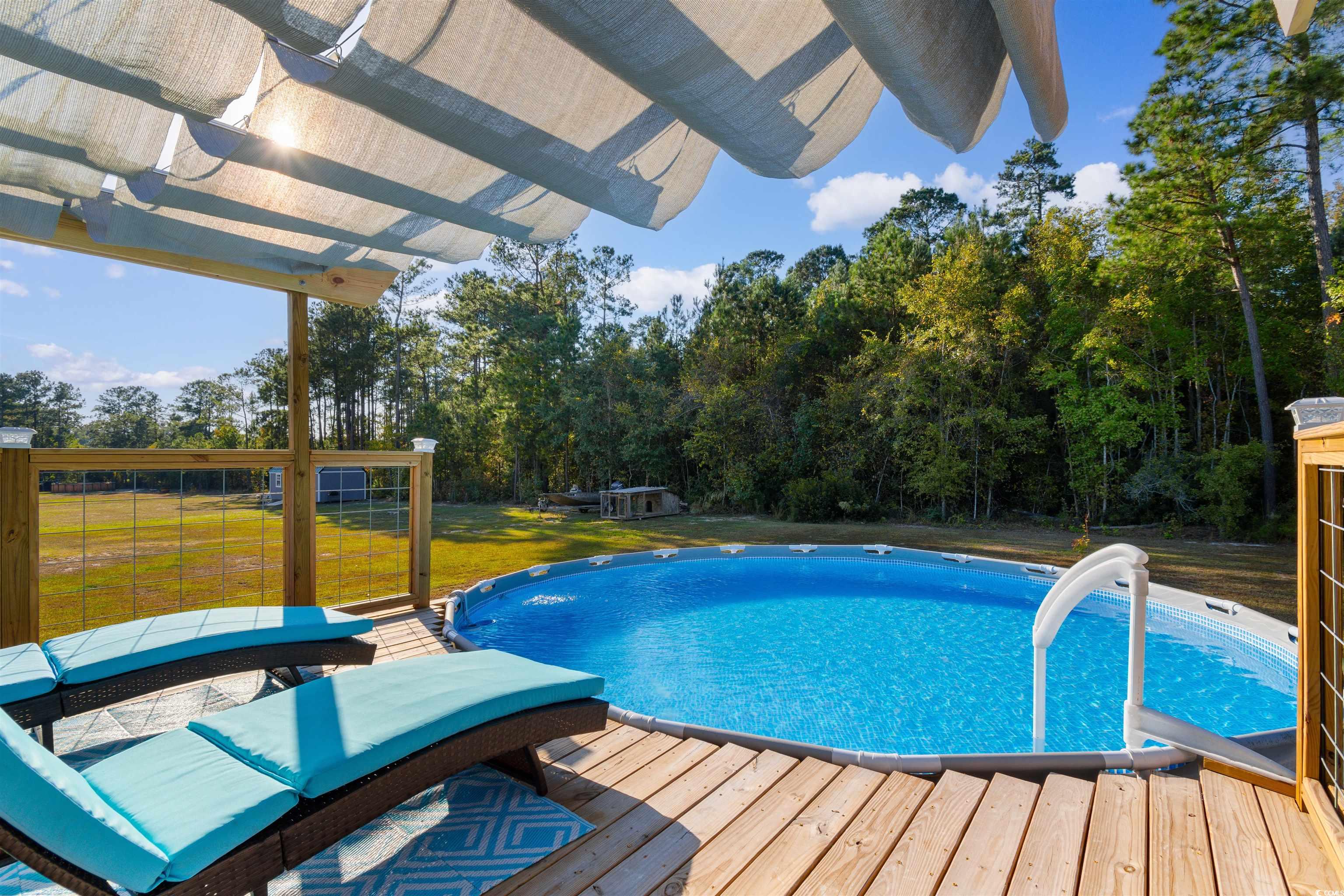 2279 Vaught Road Galivants Ferry, SC 29544 - Photo 33 of 40 View of pool featuring a deck and a lawn