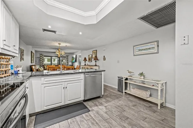 a dining room with furniture a chandelier and wooden floor