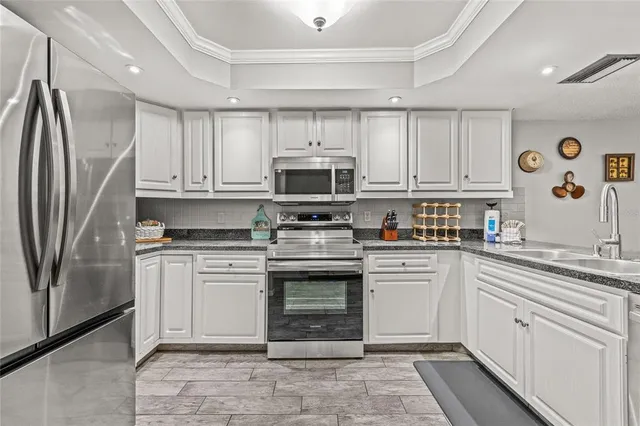 a kitchen with a refrigerator sink and cabinets